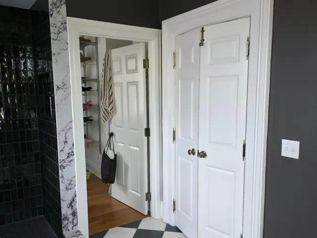 Bathroom with checkerboard tile floor and white doors