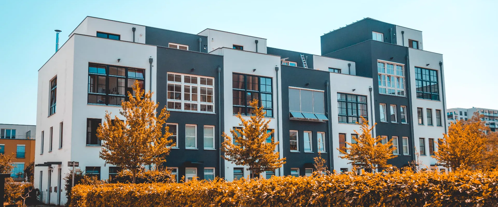 Modern multifamily apartment building exterior with white and dark blue facades