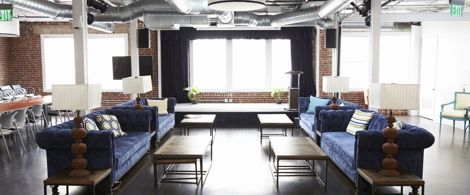 Modern shared lounge with seating and large industrial-style windows