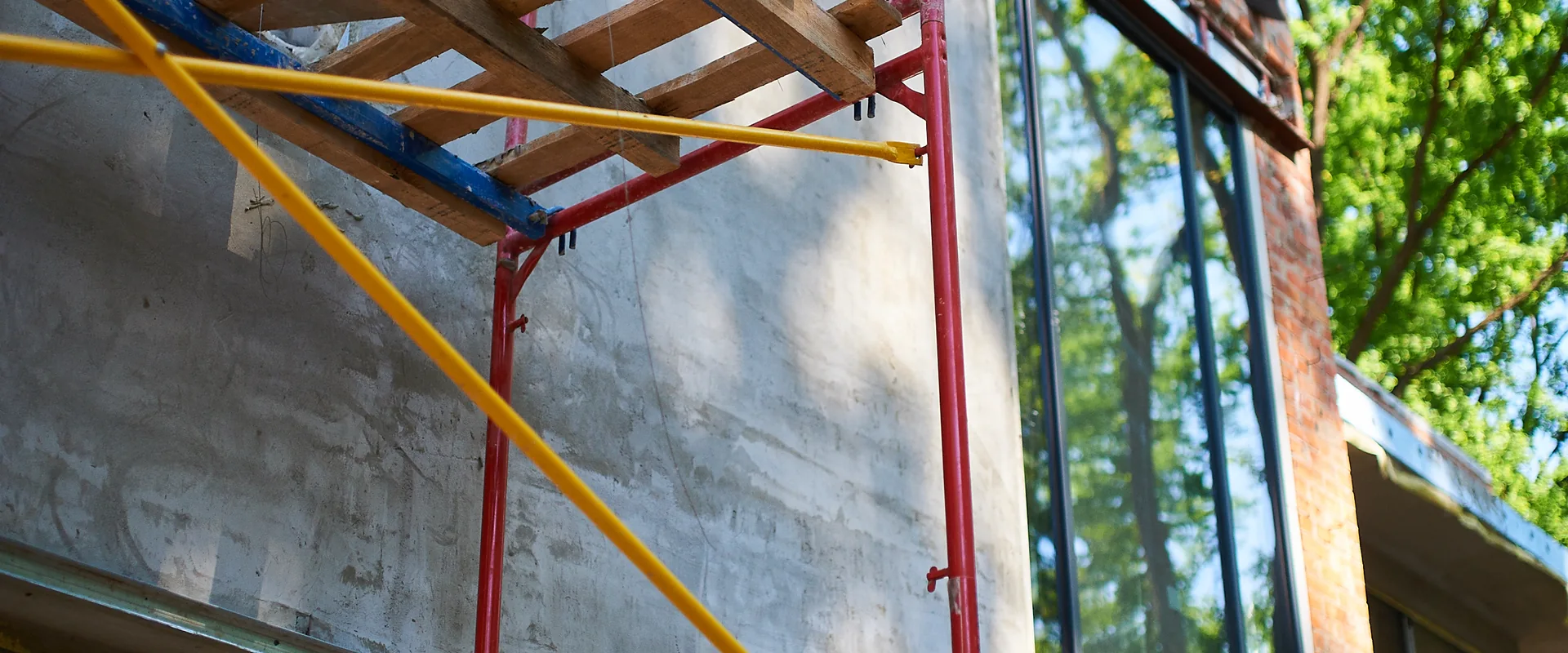 Exterior building renovation with scaffolding beside a multistory facade