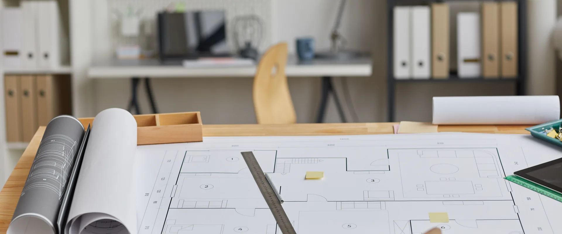 Architectural drawings and building plans spread across a planning desk