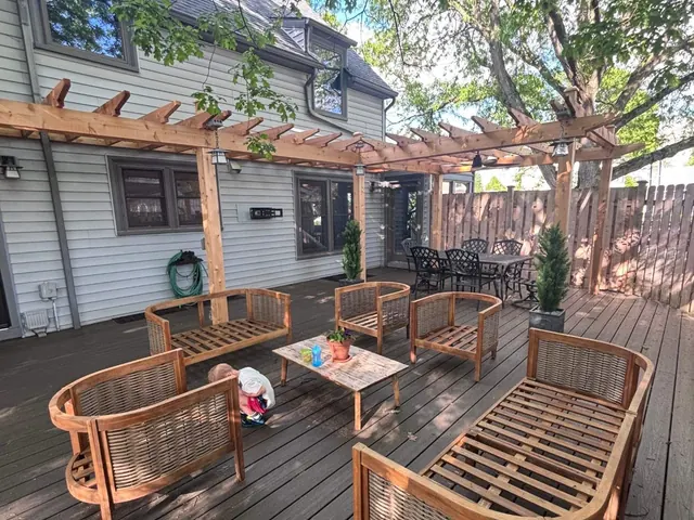 Backyard deck with wooden pergola and outdoor seating
