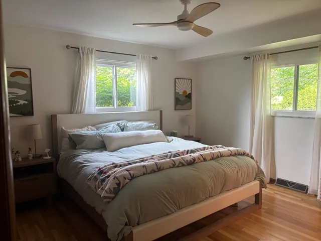 Bedroom with wood flooring and windows