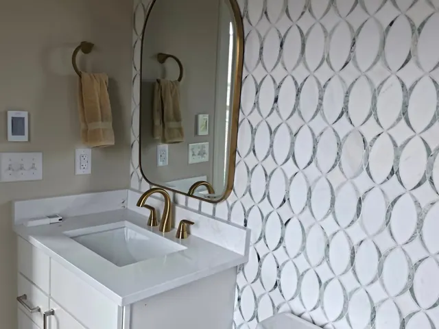 Bathroom vanity with oval mirror and patterned tile wall